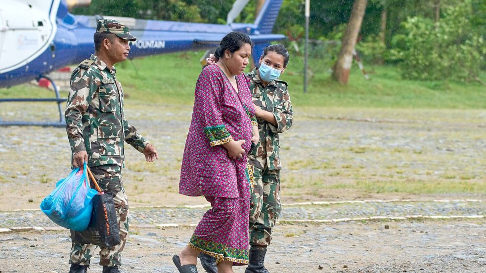 Soldaten der nepalesischen Armee helfen einer schwangeren Frau, einen Hubschrauber zu erreichen. Foto: Niranjan Shrestha