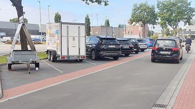 Zwei Werbeanhänger stehen auf den Parkplätzen vor Ärztehaus und Apotheke an der Fahrradstraße in Ostrhauderfehn – die übrigen Stellplätze sind belegt. Foto: Privat