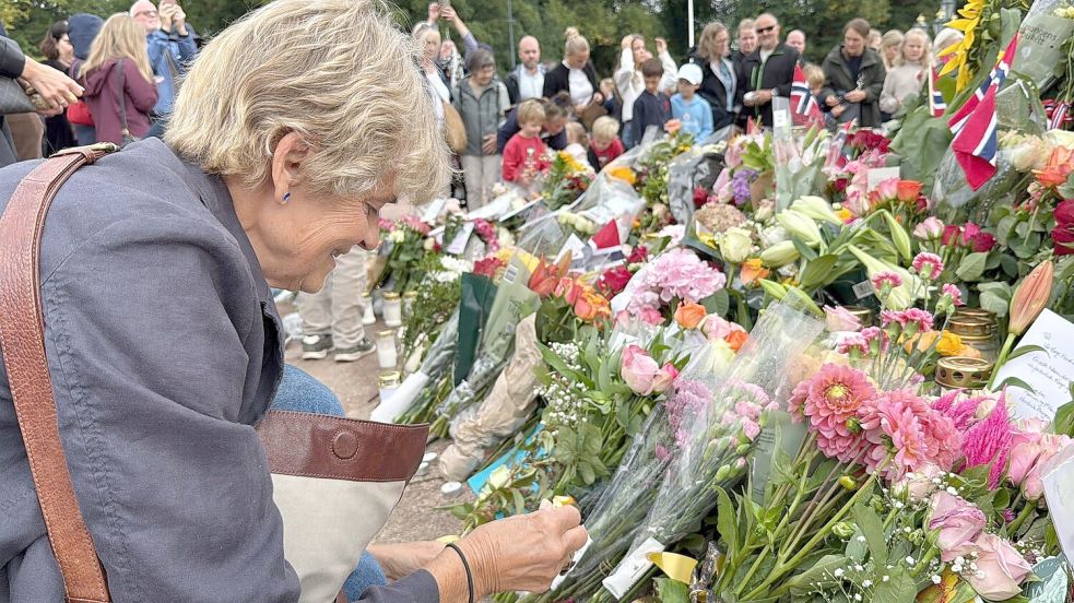 Anne Sandø Seierstad zündet eine Kerze für den gestorbenen Monarchen an. Foto: Julia Wäschenbach