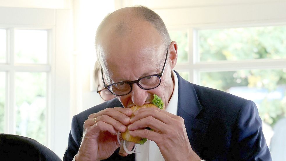 Das Fischbrötchen ließ sich der Kanzler schmecken. Foto: Bernd Wüstneck