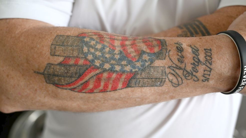 Es hat Jahre gebraucht, bis Feuerwehrmann Andrews sich nach 9/11 ein Bild der in eine amerikanische Flagge gehüllten Zwillingstürme auf den Unterarm tätowieren lassen konnte. Foto: Anne Pollmann