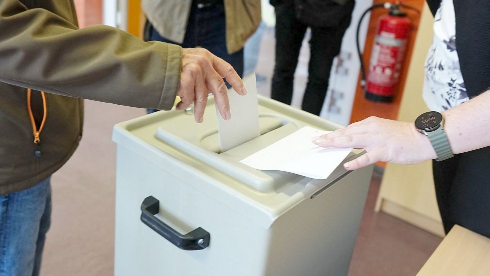 Ein Wähler wirft seinen gefalteten Stimmzettel in die Wahlurne in einem Wahllokal. Foto: Kay Nietfeld/dpa