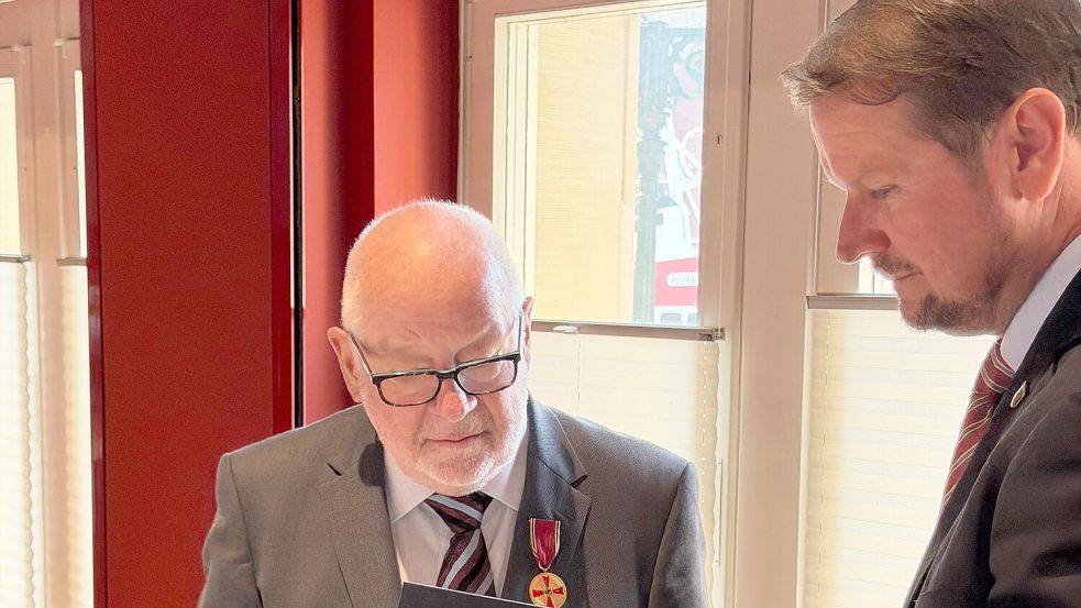 Oberbürgermeister Tim Kruithoff (rechts) überreicht Heinz-Günther Buß die Urkunde zur Verdienstmedaille des Verdienstordens der Bundesrepublik Deutschland. Foto: Stadt Emden