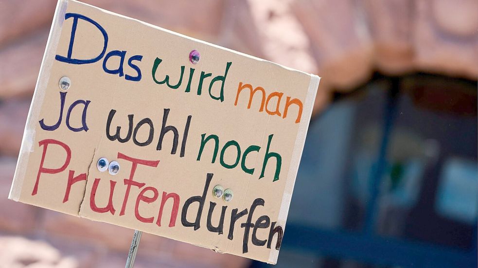 Ein Demonstrant hält ein Protest-Schild bei der Demonstration in Mainz. Foto: Sascha Ditscher