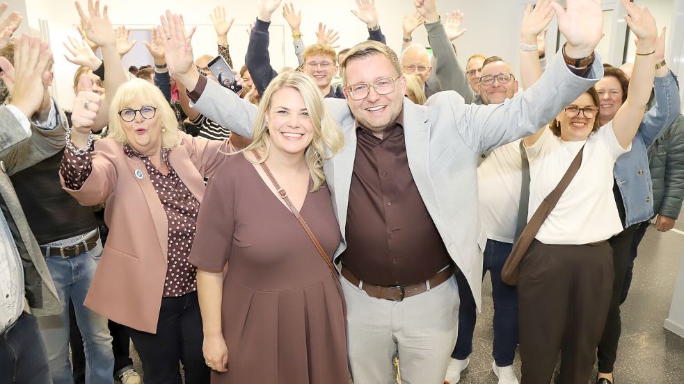 Barßels Bürgermeister Nils Anhuth feiert den Wahlsieg mit seiner Frau Steffi und seinen Unterstützern. Foto: Hans Passmann