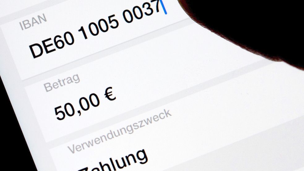 Dieses Foto zeigt die Nutzung einer App auf dem Smartphone, um im Online-Banking eine SEPA-Überweisung zu veranlassen (gestellte Szene). Foto: Monika Skolimowska/dpa-Zentralbild/dpa