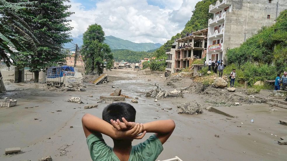 Ein Junge betrachtet die Verwüstungen durch die Sturzflut in Nepal. (Archivbild) Foto: Niranjan Shrestha/AP/dpa