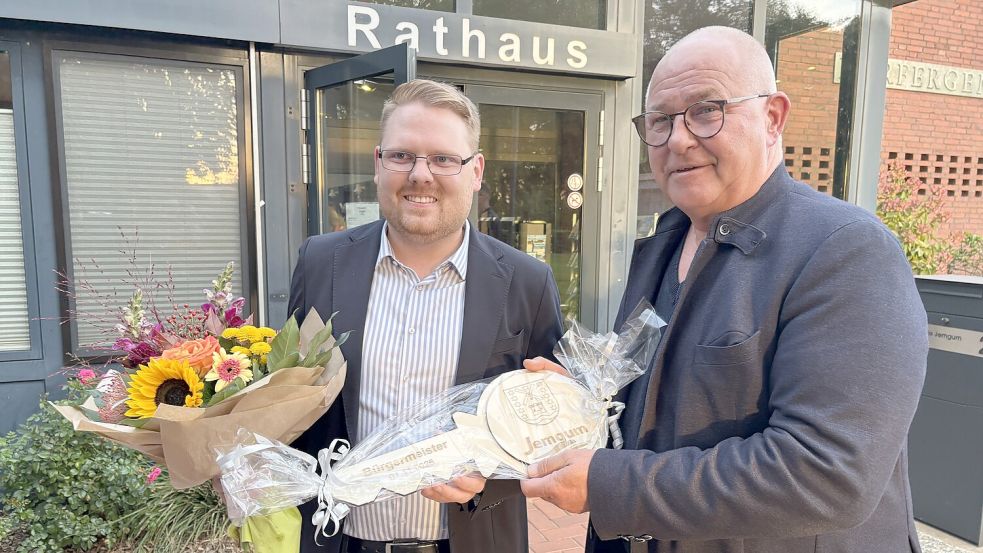 Jemgums Bürgermeister Hans-Peter Heikens (rechts) überreicht seinem gewählten Nachfolger Malte Blümel einen symbolischen Rathausschlüssel. Foto: Oliver Bär