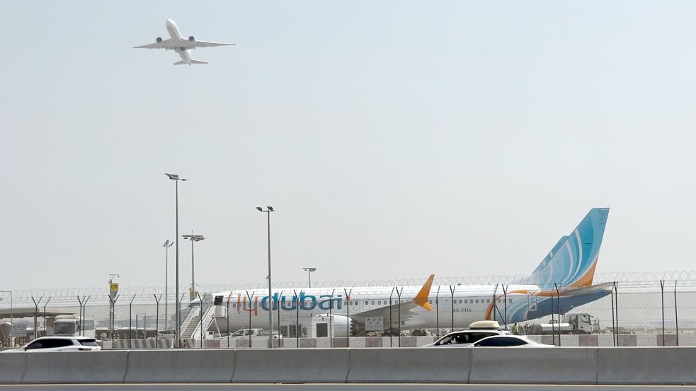 Ein Flugzeug hebt ab, während ein Flydubai-Flieger in Dubai auf dem Flughafen steht.  Foto: Uncredited/AP/dpa