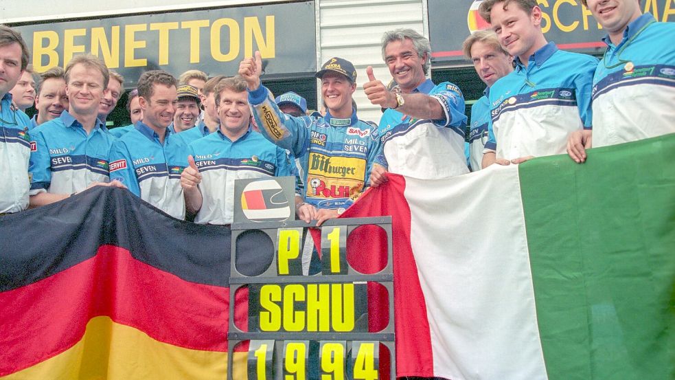 Michael Schumacher (M) jubelt mit seinem Benetton-Team über seinen WM-Titel 1994. (Archivbild) Foto: Harry Melchert/dpa