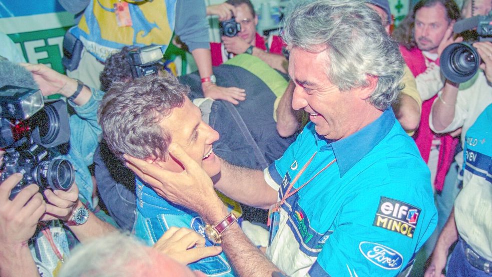 Nach seinem ersten Gesamtsieg in der Fahrer-WM 1994 wird Schumacher (l) von seinem Teamchef Flavio Briatore herzlich empfangen. (Archivbild) Foto: Harry Melchert/dpa