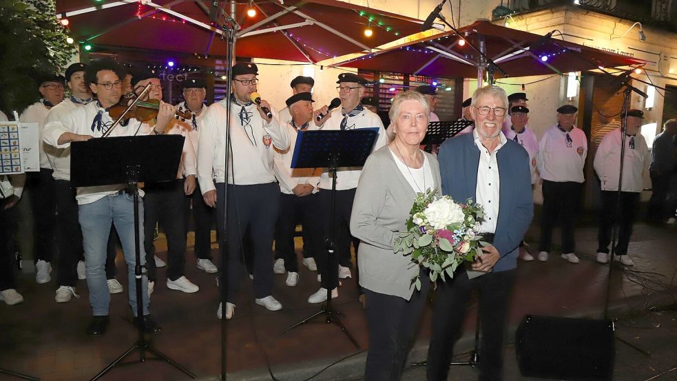 Heiner und Käthe Siemer stehen vor dem Shanty-Chor Barßel, der dem Jubelpaar zur diamantenen Hochzeit ein musikalisches Ständchen bringt. Foto: Hans Passmann