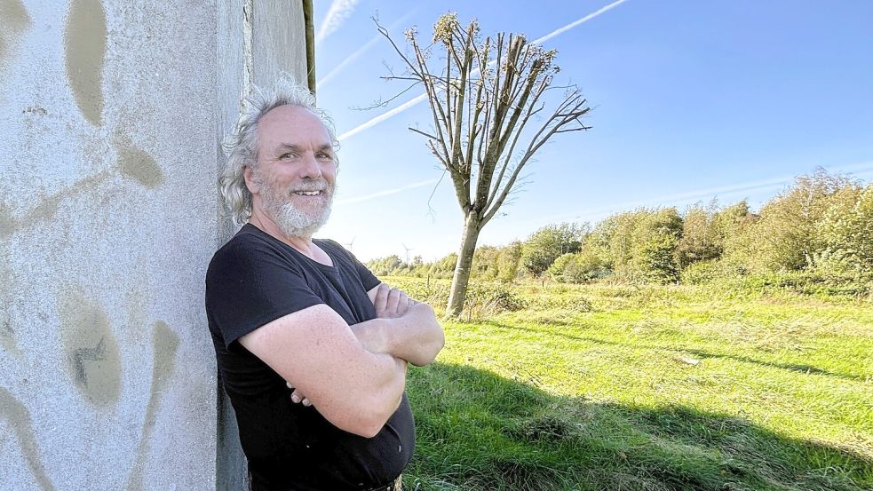 Andreas Wermerßen vor einem der Gebäude auf der früheren Raketenstation: Ausbauen wollte er es zu einem kleinen ökologischen Haus. Dazu kam es nicht. Im Hintergrund wächst einer der Bäume, die er auf dem Gelände gerettet hat. Foto: Nicole Böning