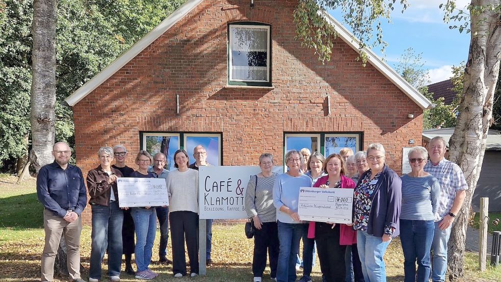 Scheckübergabe vor Café & Klamotte: Pastor Karl Karzelek, Hella Freerks, Gesa Brödje, Stephanie Kruse, Ria Müntinga, Kea Bünnemeyer und Maike Hupens mit Ehrenamtlichen des Werks. Foto: Café & Klamotte