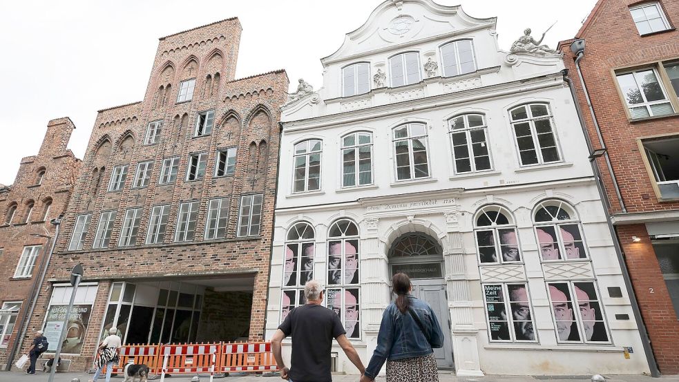 Passanten betrachten das geschlossene Buddenbrookhaus in der Lübecker Altstadt. Foto: Christian Charisius/dpa