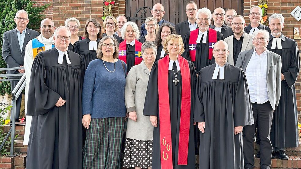 Nach der Ordination versammelten sich vor der Kirche Mitglieder der Dienstgemeinschaft im Kirchenkreis und weitere Beteiligte zum Gruppenfoto. In der ersten Reihe sind von links zu sehen: Superintendent Thomas Kersten, Marlene Wagner, Stefanie Hanekamp, Regionalbischöfin Sabine Schiermeyer, Pastor Dr. Sören Petershans und Pastor im Ruhestand, Michael Schaper. Foto: Andreas Engel/Kirchenkreis Rhauderfehn