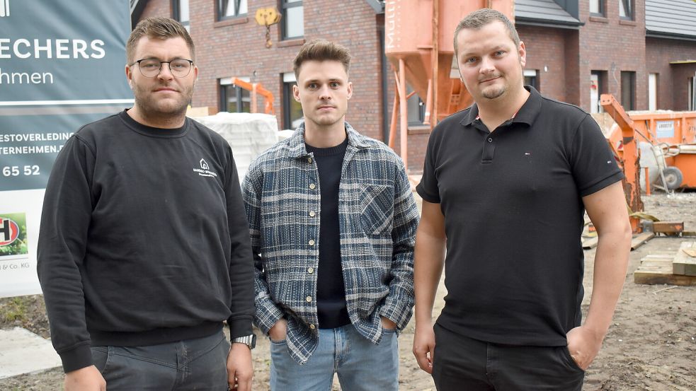 An der Mozartstraße in Rhauderfehn entstehen derzeit drei Vierparteienhäuser. Im Bereich der Baustelle gibt es Streit um einen beschädigten Glasfaseranschluss. Nun beziehen die Grundstückseigentümer (von links) Sandro Wiechers, Keno Bösker und Jan Groen Stellung zu den Vorwürfen der Deutschen Glasfaser. Foto: Henrik Zein