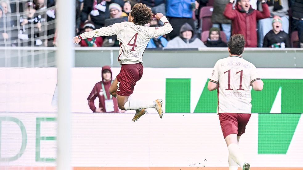 Han-Noah Massengo hebt nach seinem 1:0 jubelnd ab - zum Sieg reichte sein Kopfballtor für den FC Augsburg aber nicht.  Foto: Harry Langer/dpa
